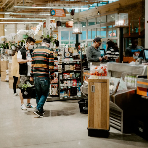 people wearing masks at a supermarket check out